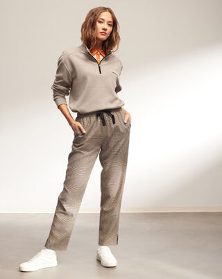 woman wearing pants and a pullover and a polo